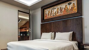 Une chambre d’hôtel moderne avec un grand lit, une tête de lit en bois et un panneau décoratif mural.