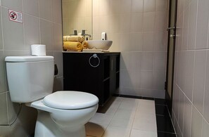 A small bathroom with a toilet, sink, and a towel rack. - Tanjung Lima Hotel Legian (Legian)