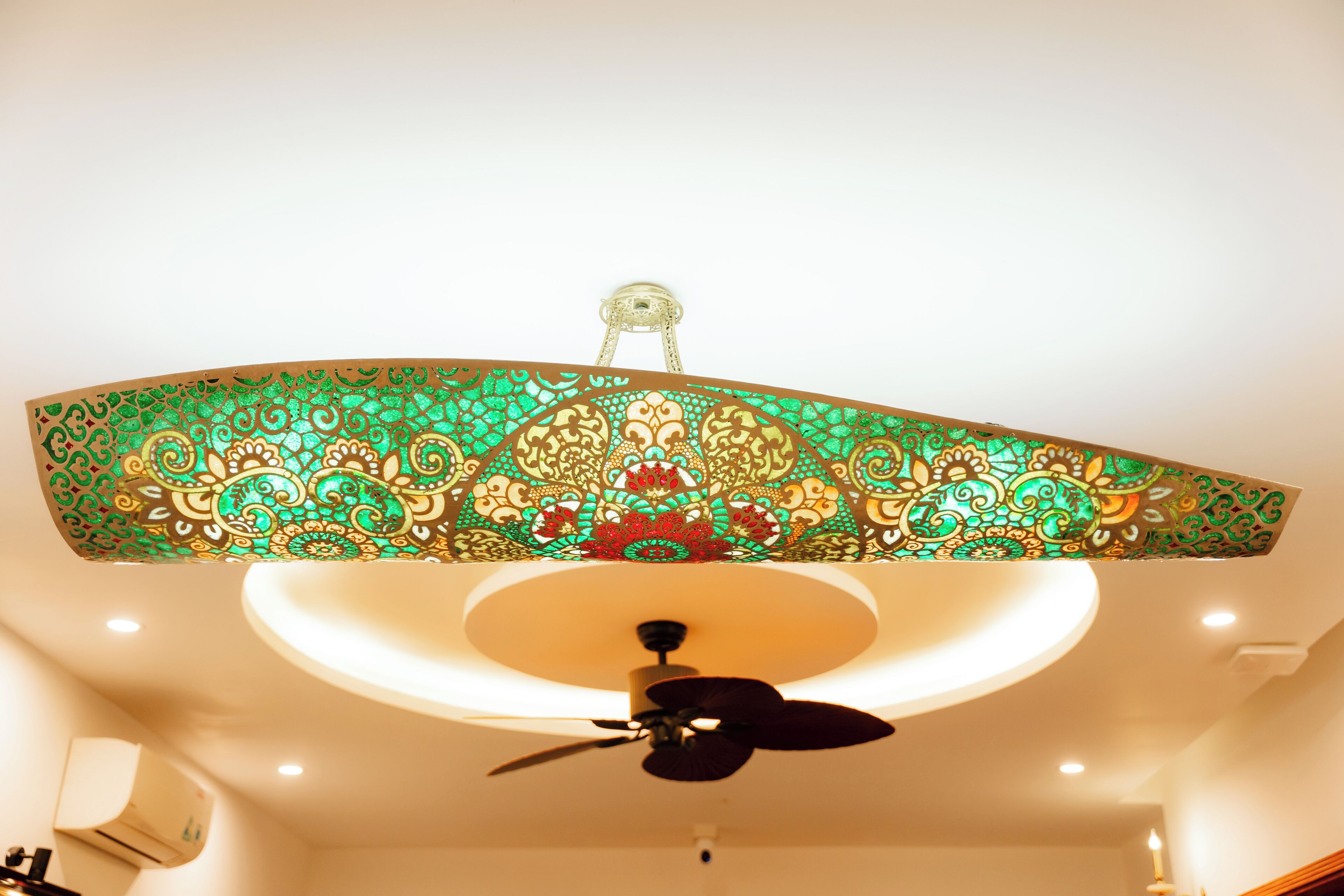 A ceiling fan with a decorative light fixture above it.