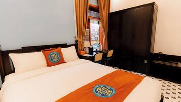 A hotel room with a bed, a desk, and a wardrobe.