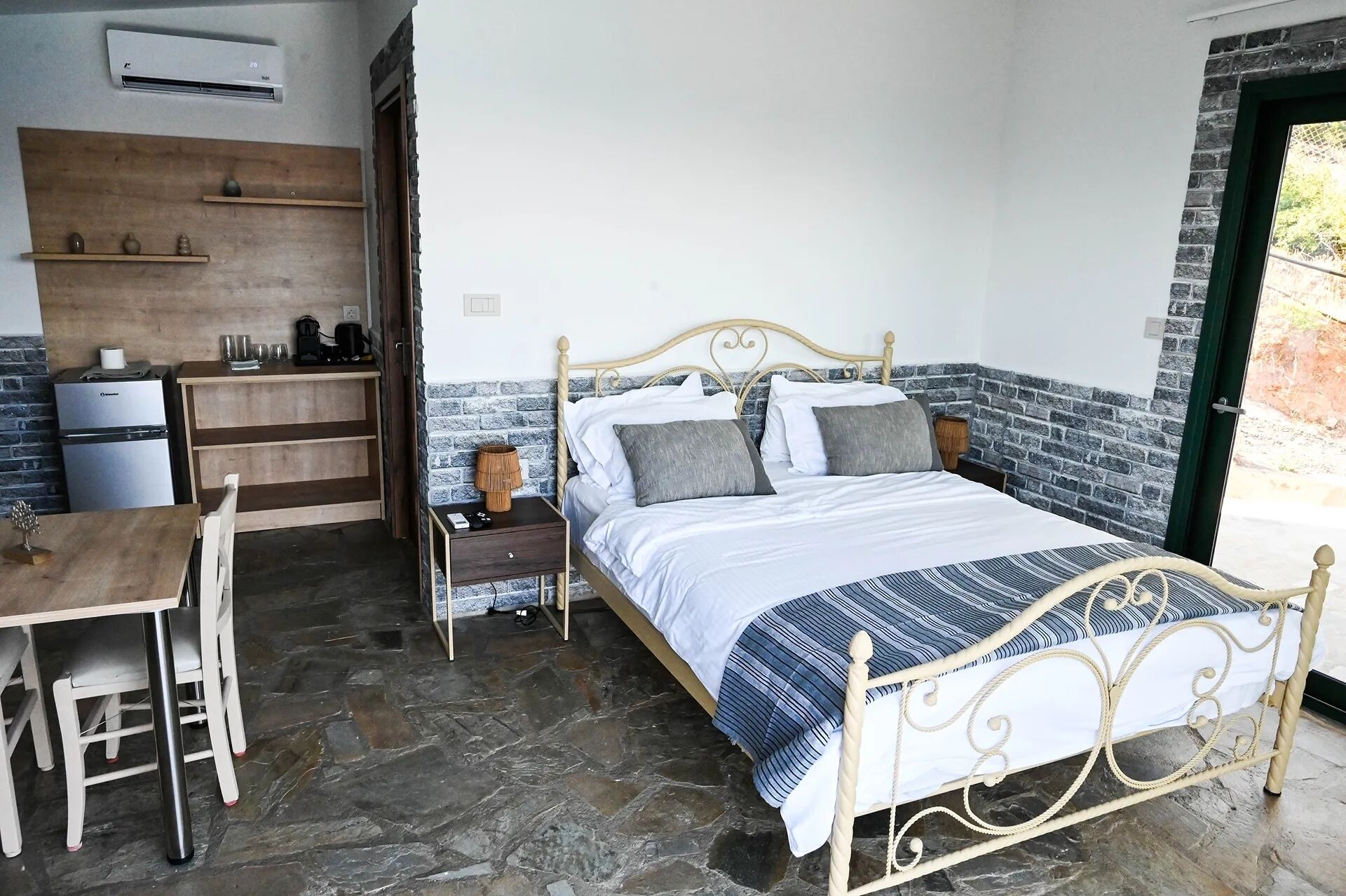A bedroom with a bed, bedside table, and a small desk with a chair.