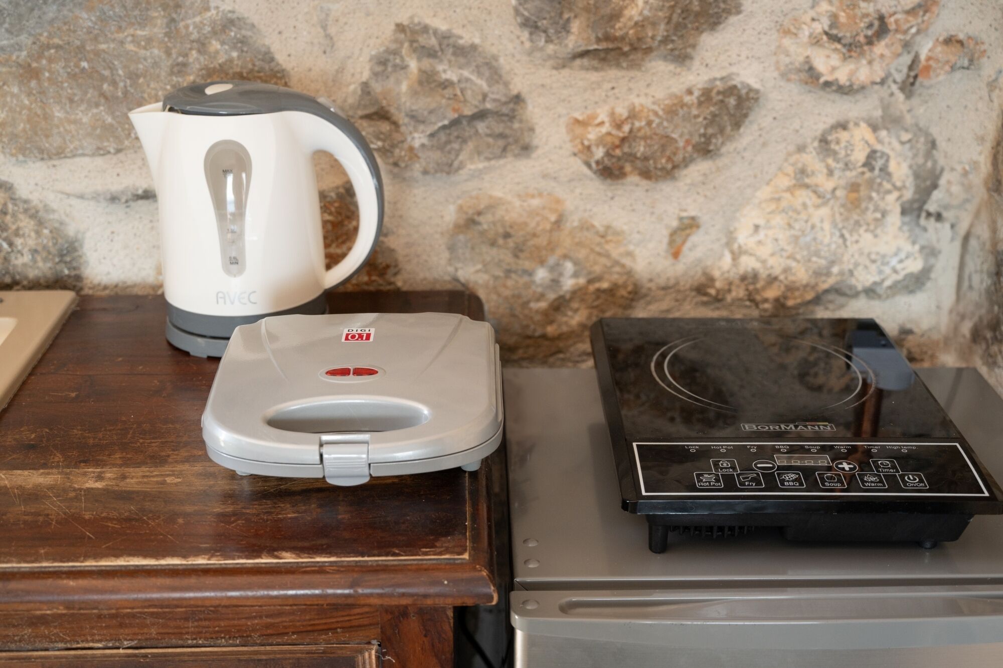 A kitchen with a coffee maker, a digital scale, and a microwave.