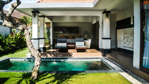 Une maison moderne dotée d’une piscine, d’un espace extérieur aménagé et d’un jardin bien entretenu.