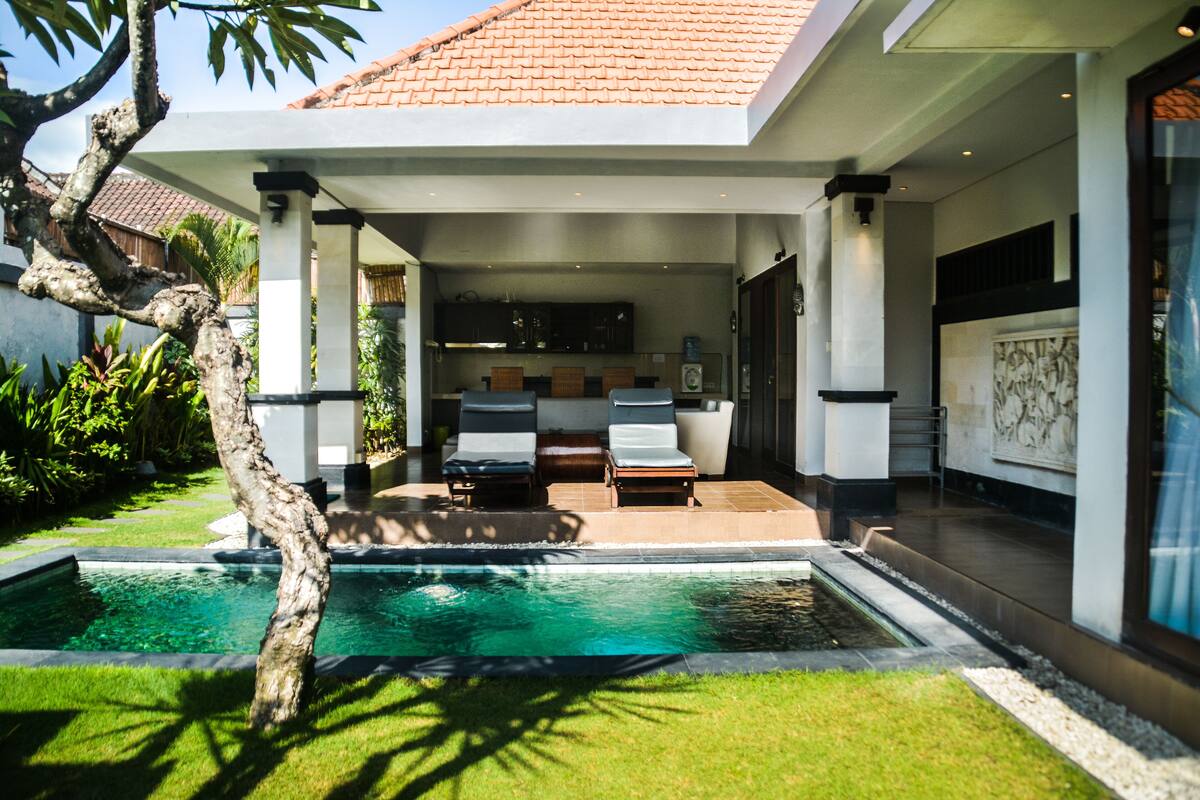 Une maison moderne dotée d’une piscine, d’un espace extérieur aménagé et d’un jardin bien entretenu.