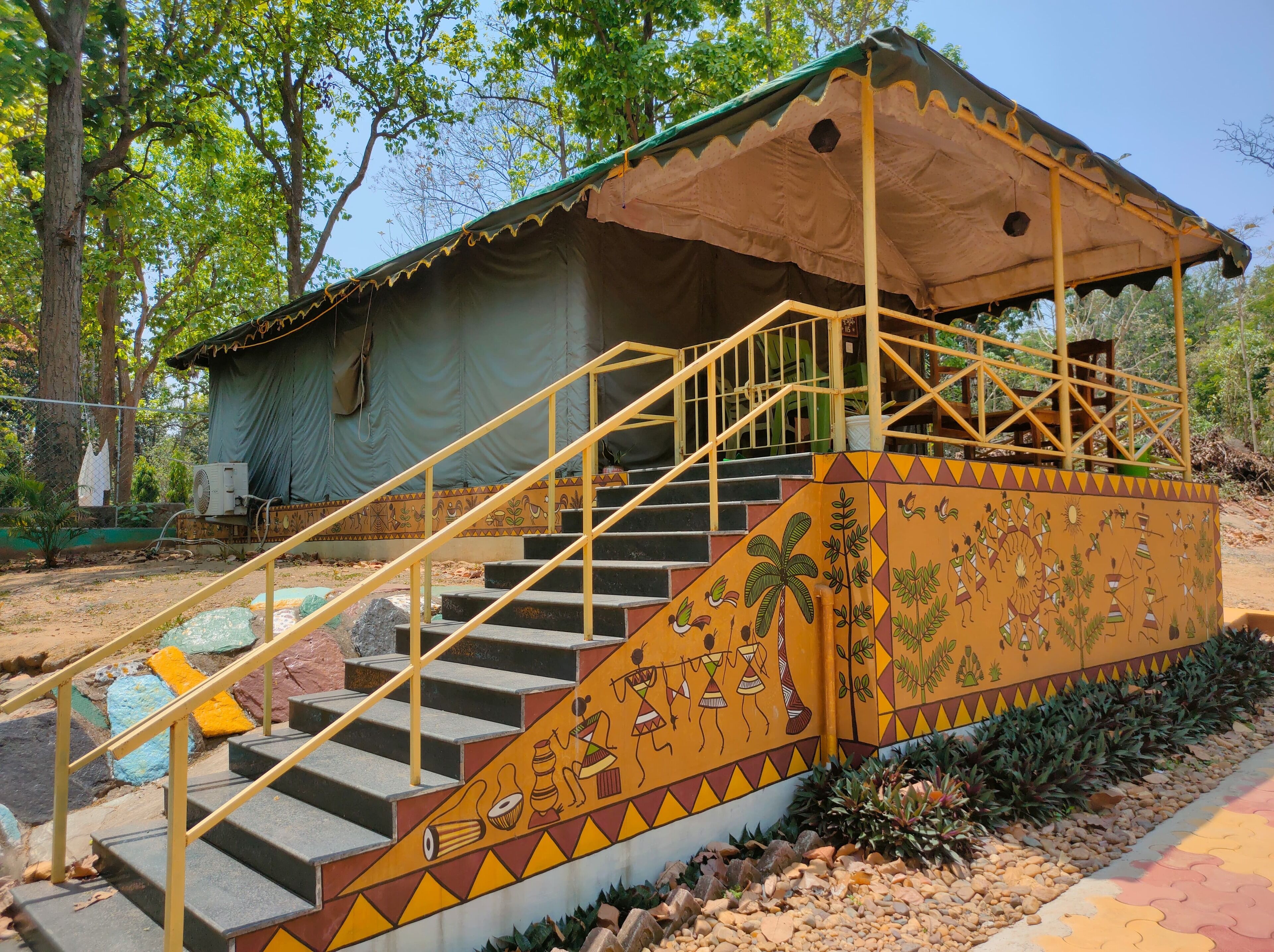 A building with a covered staircase and a mural with cultural designs.