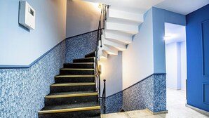 A staircase with a handrail, carpeted steps, and a wall-mounted light fixture. - Room-deluxe Double Room 4 (Istanbul)