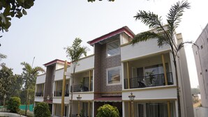 Ein mehrstöckiges Wohngebäude mit Balkonen, einem Gartenbereich und blauem Himmel.