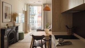 A modern kitchen with a dining area, a fireplace, and a view of the cityscape. - Líbere Bilbao Ledesma (Bilbao)
