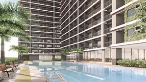 A modern building with a swimming pool, multiple balconies, and greenery. - 1 BR Fully Furnished Condo in Makati with Pool and Parking - Red Res. Unit 1133 (Makati)
