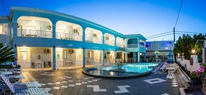 A hotel with a pool, outdoor seating, and multiple balconies. - Anna's Studios & Apartments (Zakynthos)
