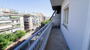 Un balcon donnant sur un paysage urbain, avec des bâtiments et une rue.