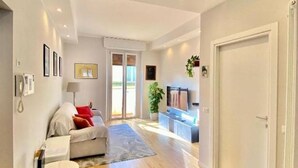 Un salon moderne avec un canapé, un téléviseur et une porte.