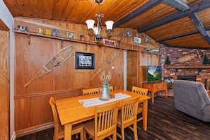 A wooden dining area with a table, chairs, and a television. - PET FRIENDLY! Fully Fenced Yard! Close to the Convention Center! 2 Master Suites! (Big Bear City)