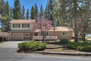 A two-story house with a stone facade, a garage, and a small porch.