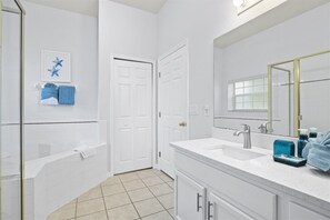 Bathroom features a large bathtub, double sink vanity, and shower area.