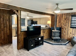 A living room with a television, a fireplace, and a sofa. - Chalets Plus Canada S.e.n.c (Saint-Gabriel-de-Brandon)