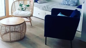 Ein Schlafzimmer mit einem Bett, einem Sessel, einem runden Tisch und einem großen Fenster.