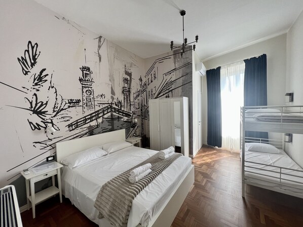 Ein Hotelzimmer mit einem großen Bett, einem Nachttisch, einem Kleiderschrank, einer Heizung und einem Etagenbett.