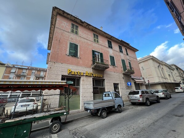 A building with a sign reading "Pasta All'Uovo" on the ground floor.