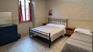 A bedroom with a single bed, a dresser, a window with curtains, and a small bedside table. - Casa Vacanze Il Conservatorio - by Be Your Home (Civitavecchia)