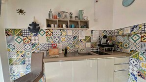 Een keuken met een backsplash van visgraat tegels, een houten stoel en een spoelbak.