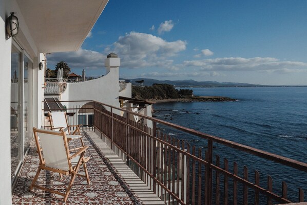 A balcony with a view of the sea, wooden chairs, and a tiled floor. - Holiday Apartment by the sea (Santa Marinella)