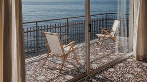 A balcony with two wooden chairs and a glass door. - Holiday Apartment by the sea by Be Your Home (Santa Marinella)