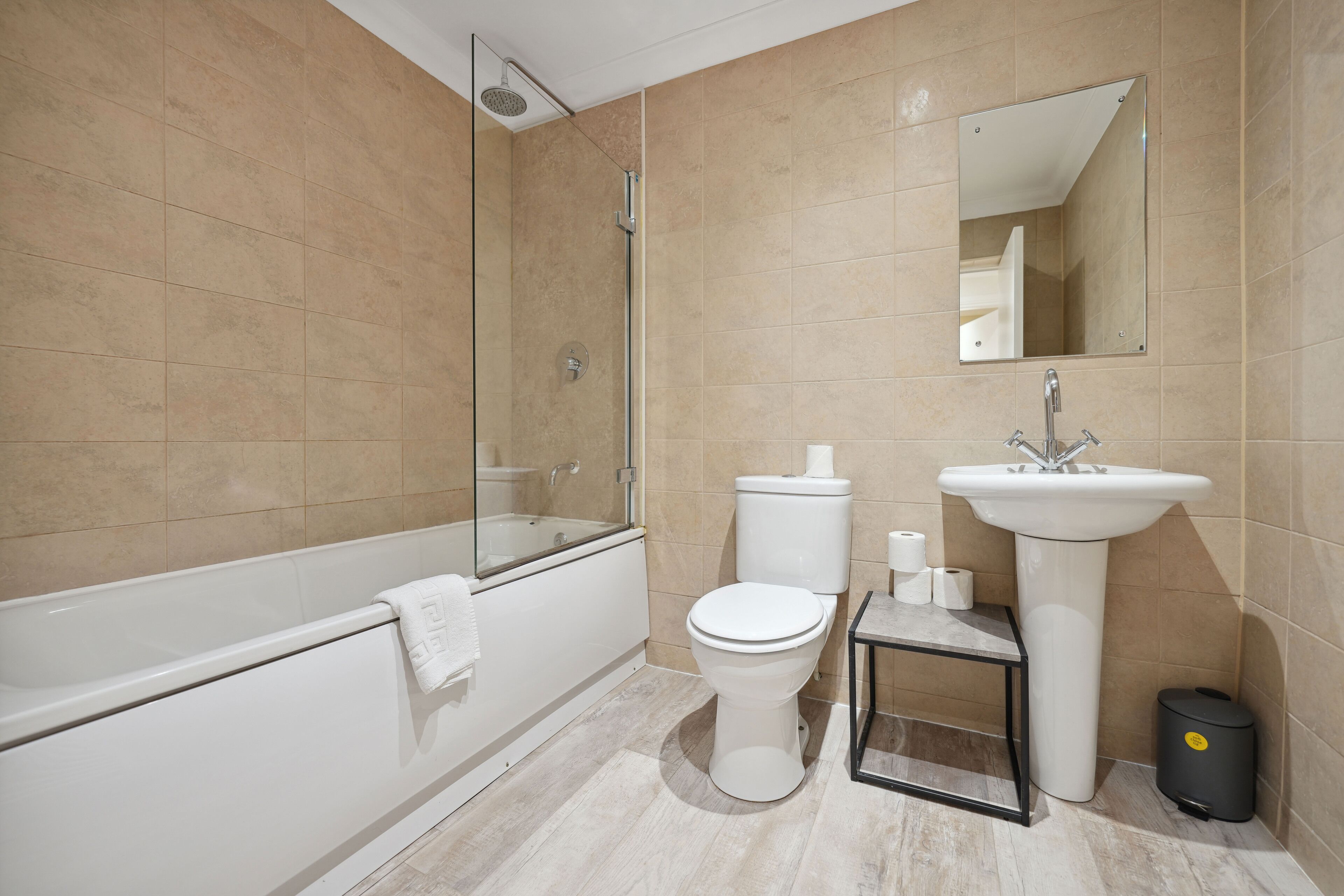 A modern bathroom with a bathtub, toilet, and sink.