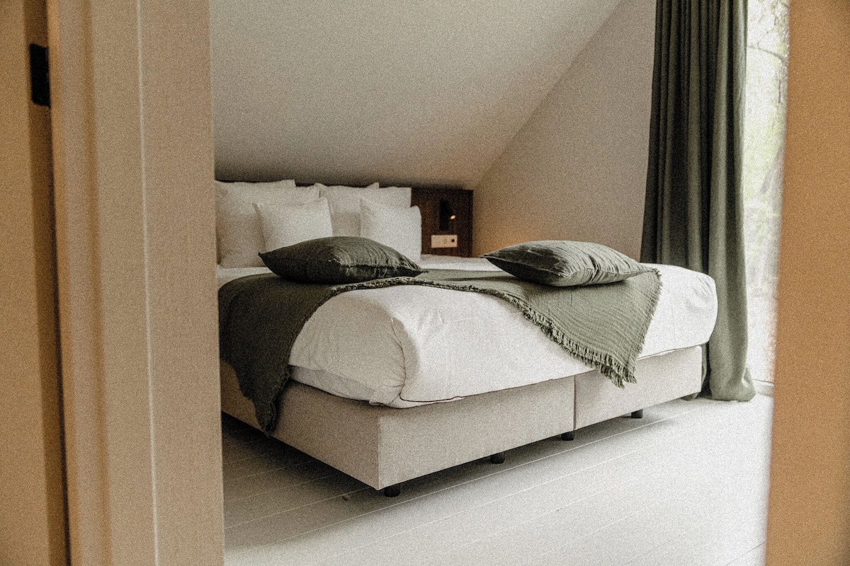 Ein Schlafzimmer mit einem Bett, Kissen und einer Decke.