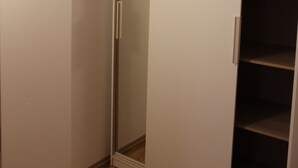 Ein begehbarer Kleiderschrank mit Schiebetür und mehreren Einlegeböden.