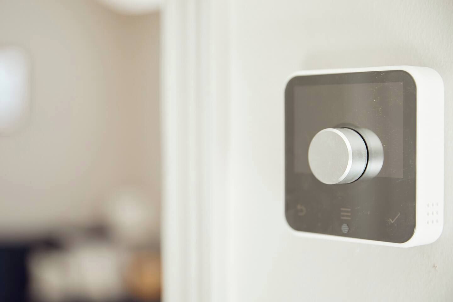 A modern, square-shaped digital lock on a door.