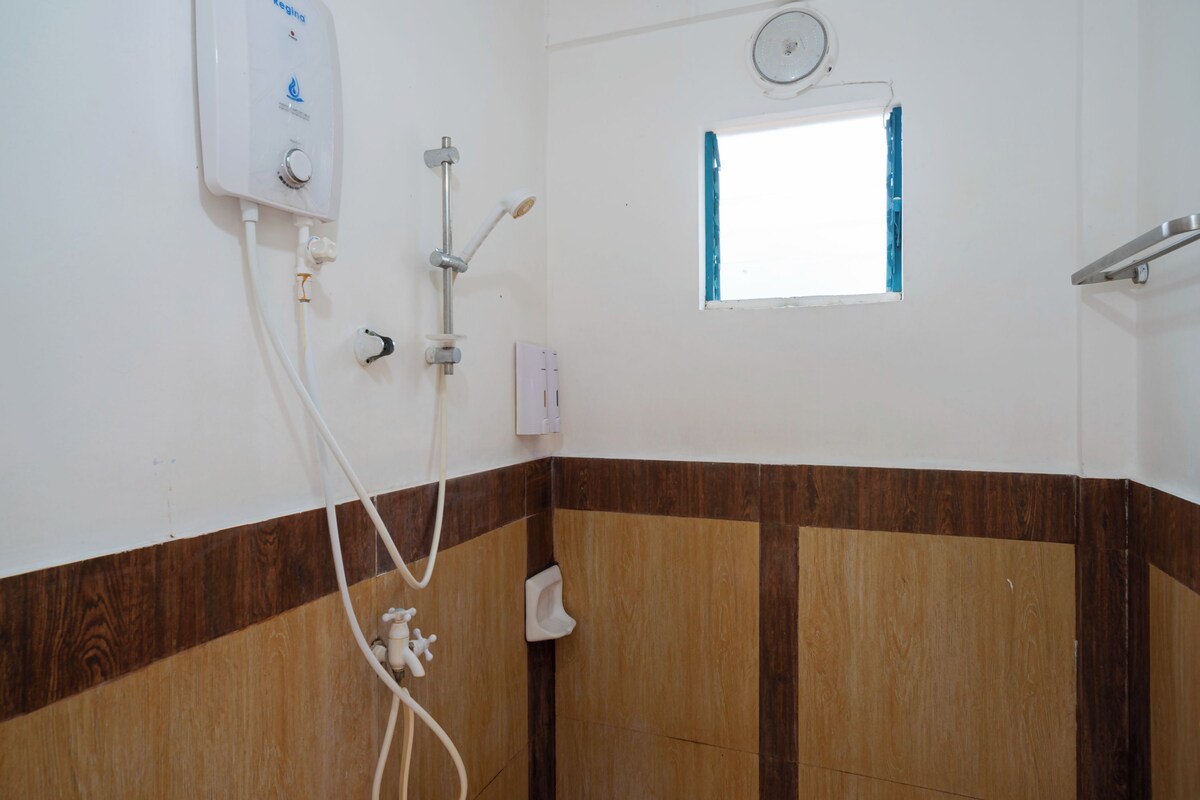 Ein Badezimmer mit Dusche, Fenster und einer an der Wand befestigten Waage.
