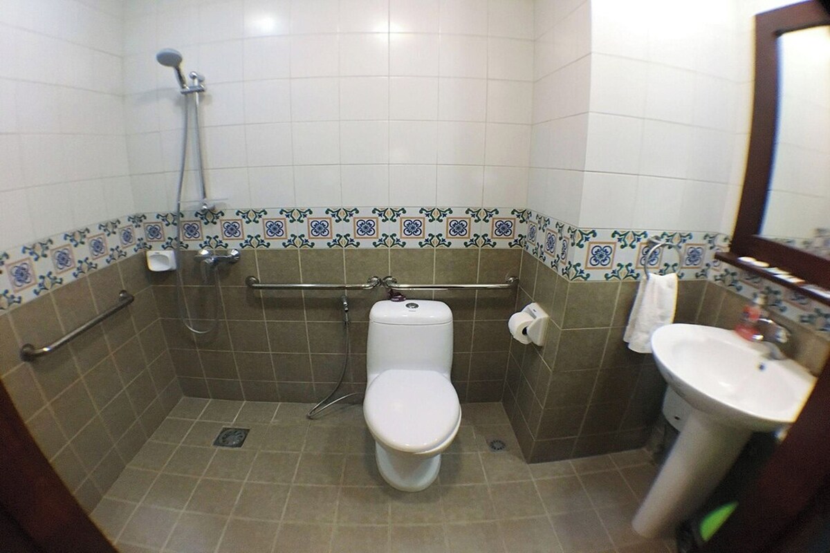 A small bathroom with a toilet, a sink, and a shower.