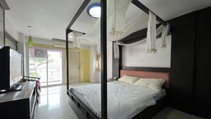 A modern bedroom with a bed, bedside table, and a view of the outside. - Phongsathon Mansion (Bangkok)