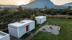 Un edificio moderno con techo plano, rodeado por un césped cuidado y una pequeña zona con hogar.