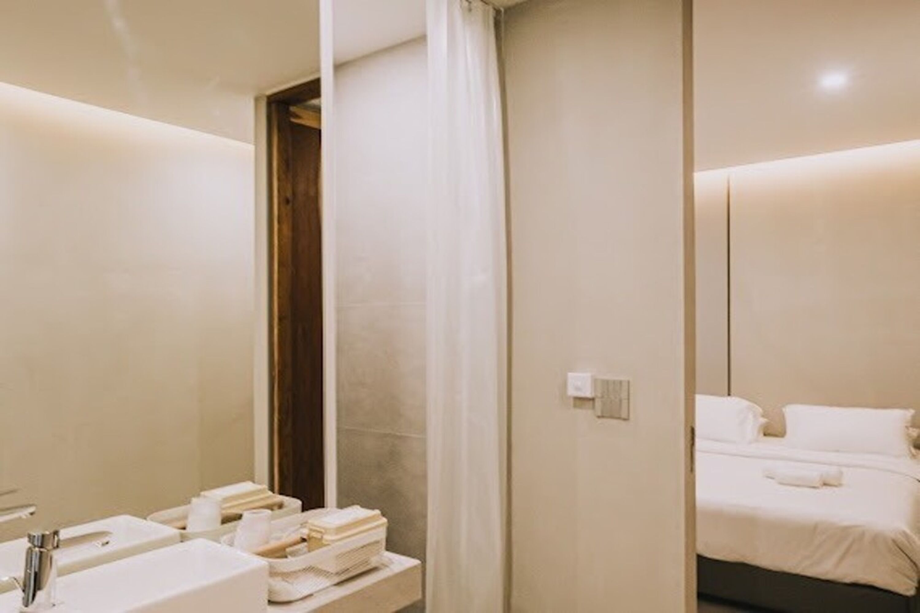 A modern bathroom with a large mirror, a sink, and a shower area.