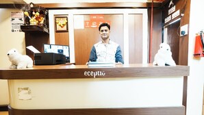 A reception desk with a wooden finish and a sign that reads "ecptio". - Hotel Della Comfort near Ambreshwar Shiv Mandir, Ambernath (Ambernath)
