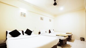 A hotel room with two beds, white linens, and a ceiling fan. - Hotel Della Comfort near Ambreshwar Shiv Mandir, Ambernath (Ambernath)