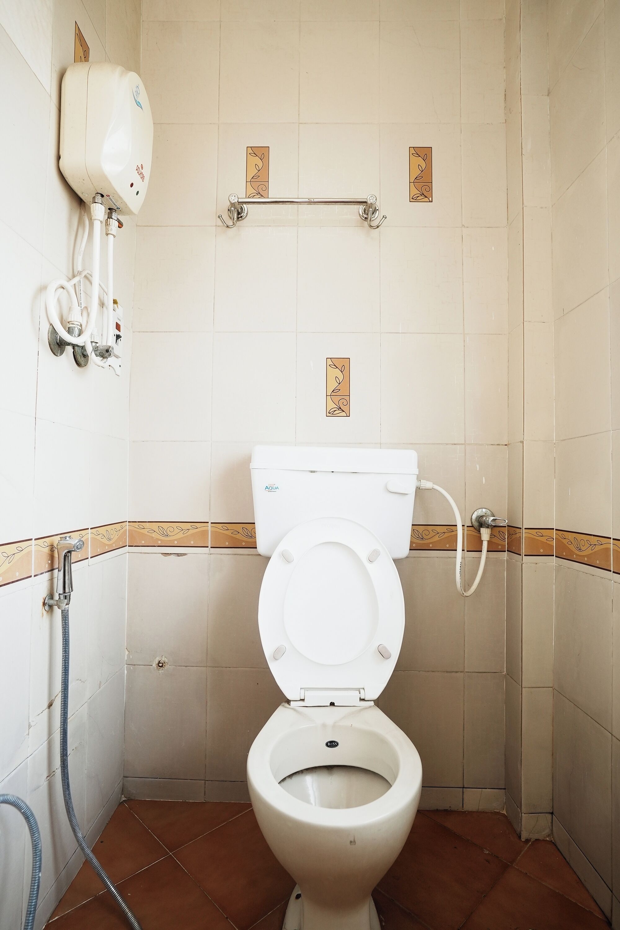 A bathroom with a toilet, a hand dryer, and a handwashing station.
