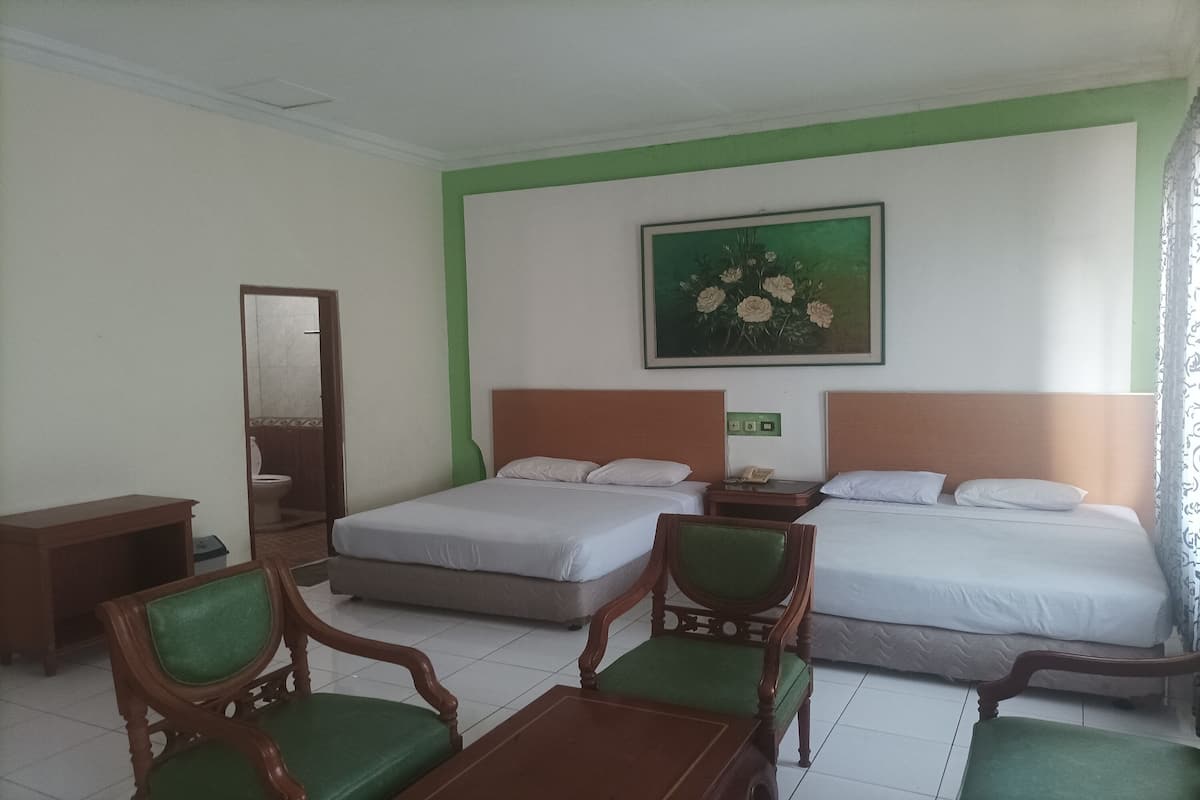 Une chambre d’hôtel avec deux lits, un bureau en bois, une chaise et un tableau au mur.