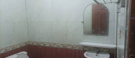 Ein Badezimmer mit Toilette, Waschbecken und Duschbereich.
