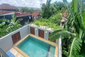 A rooftop pool with a clear view of surrounding buildings and lush greenery. - Tresna Villa 7 (Nusa Dua)