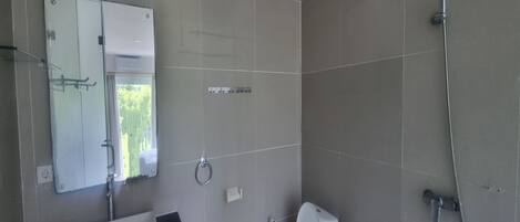 Un baño con inodoro, lavamanos y ducha.