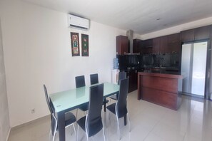 A modern kitchen with dark cabinets, a stainless steel refrigerator, and a built-in oven. - Tresna Villa 7 (Nusa Dua)