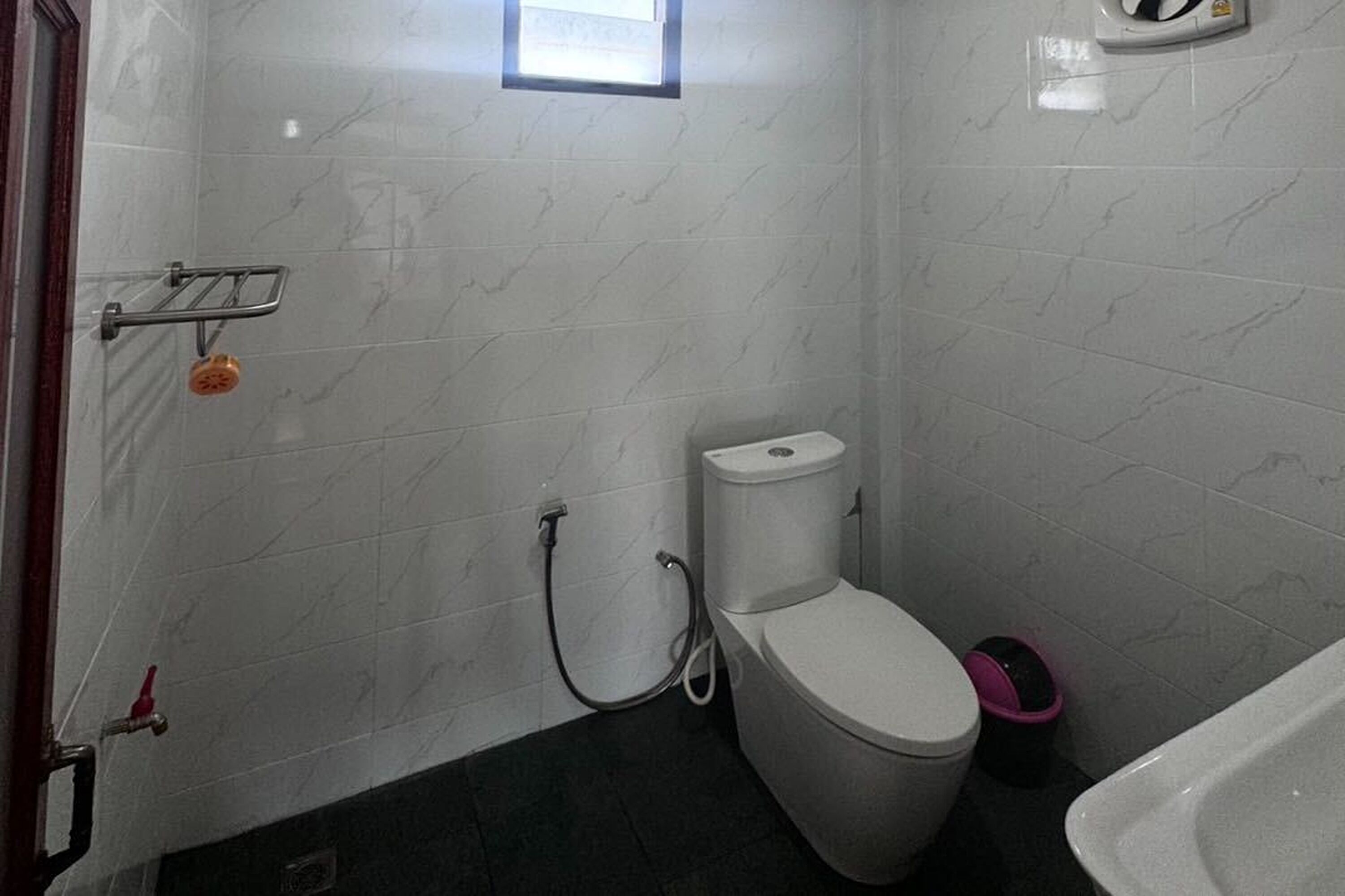 Et lille badeværelse med toilet, brusebad og badekar.