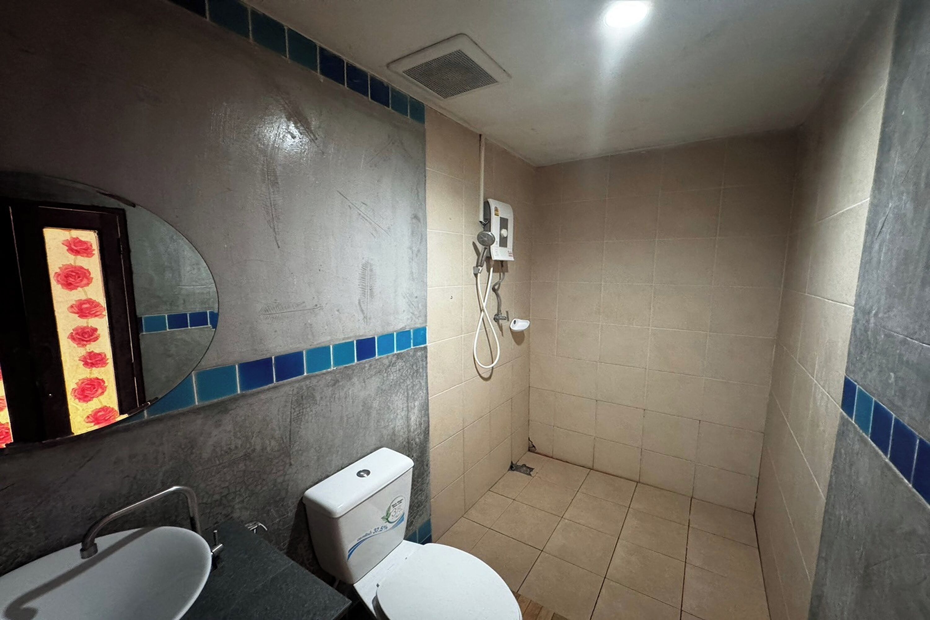 A bathroom with a toilet, sink, and shower.