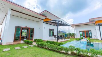 Uma casa moderna com piscina, varanda coberta e um jardim bem cuidado.
