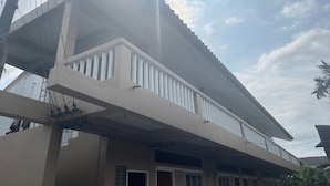 A two-story building with a balcony, a door, and a staircase. - Andaman Residence (Thep Krasattri)