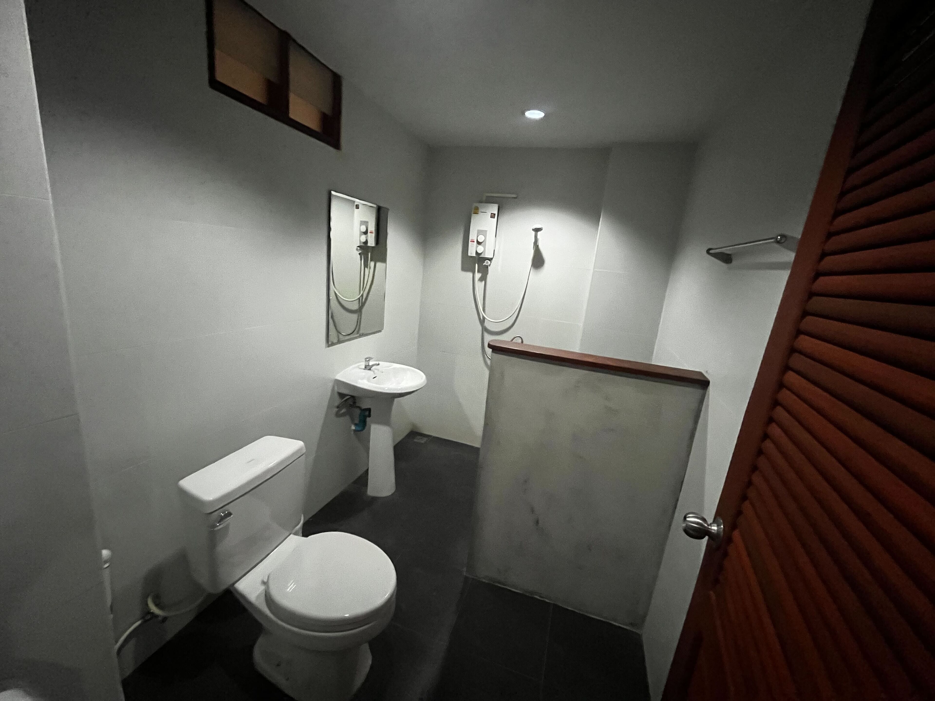 Un baño pequeño y funcional con inodoro, lavabo y ducha.
