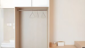 A minimalist bathroom with a white sink, a towel rack with three towels, and a small basket on the counter. - Prix Hotel (Chiang Mai)